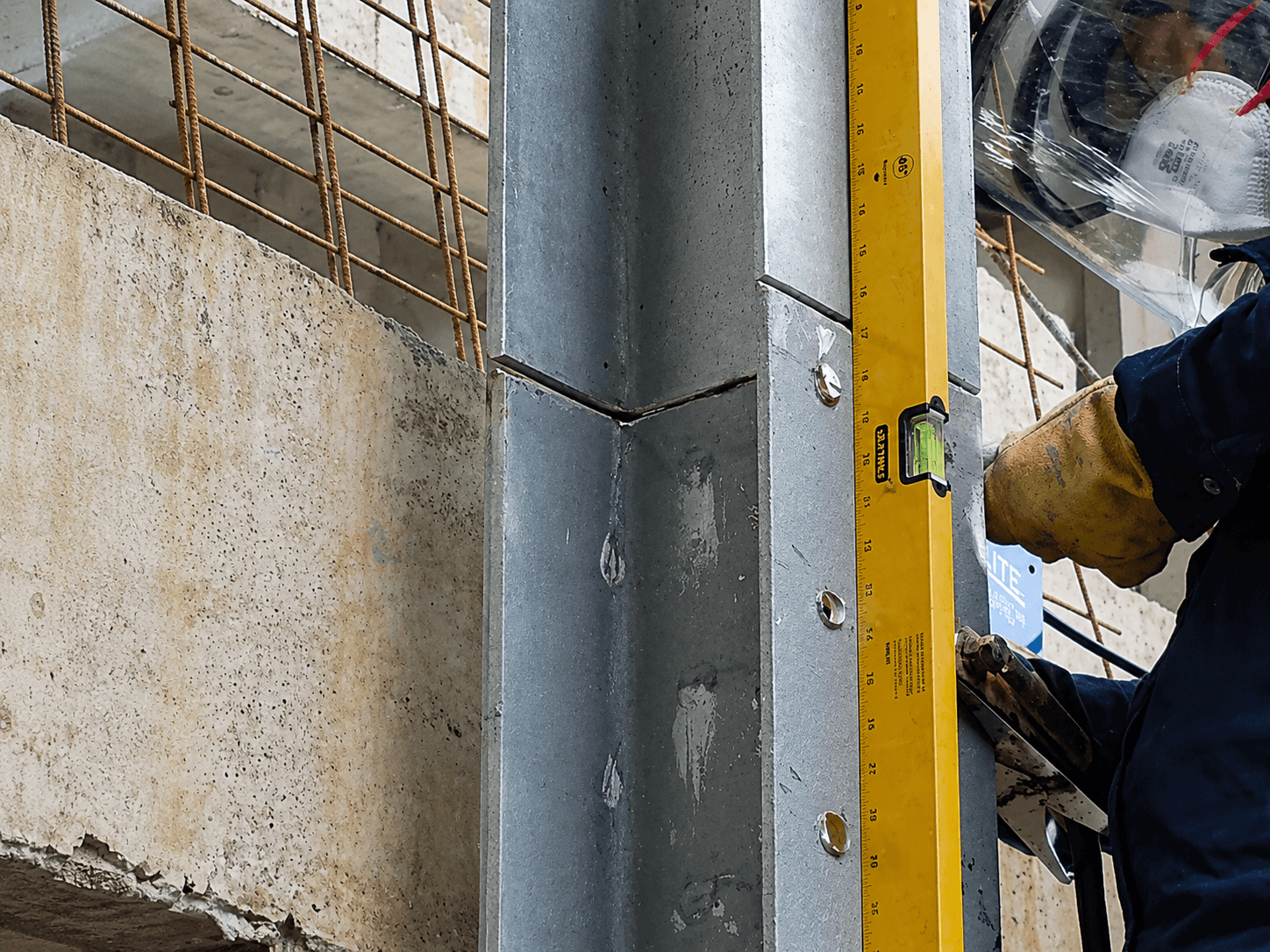 Nivel de burbuja midiendo la escuadra de un empalme en Z entre dos perfiles de acero en obra